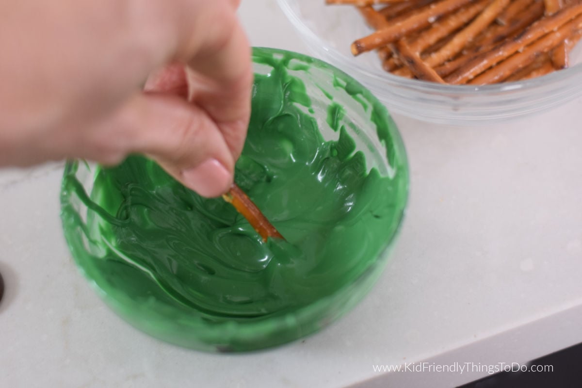 dipping pretzel into chocolate