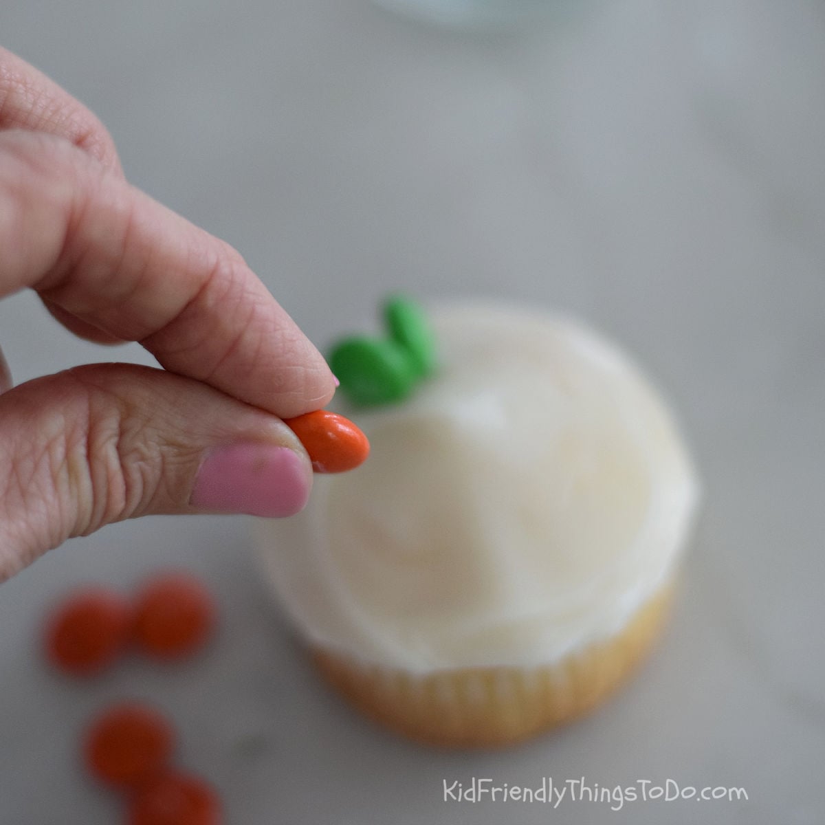 adding M&Ms to carrot cupcakes