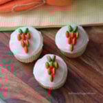 Carrot cupcakes decorated with white frosting and orange and green M&Ms for an easy Easter treat idea