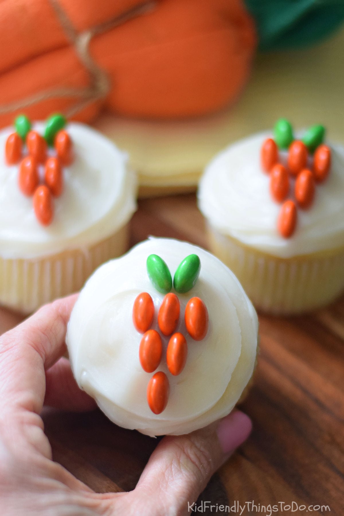 Easy Easter carrot cupcakes made with M&Ms and white frosting on vanilla cupcakes