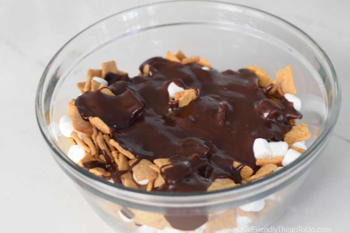 melted chocolate over cereal mixture in bowl 