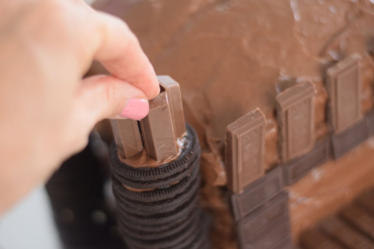 adding candy to castle towers on cake 