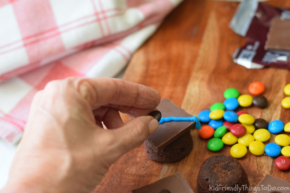 adding candy to brownie bite graduation caps