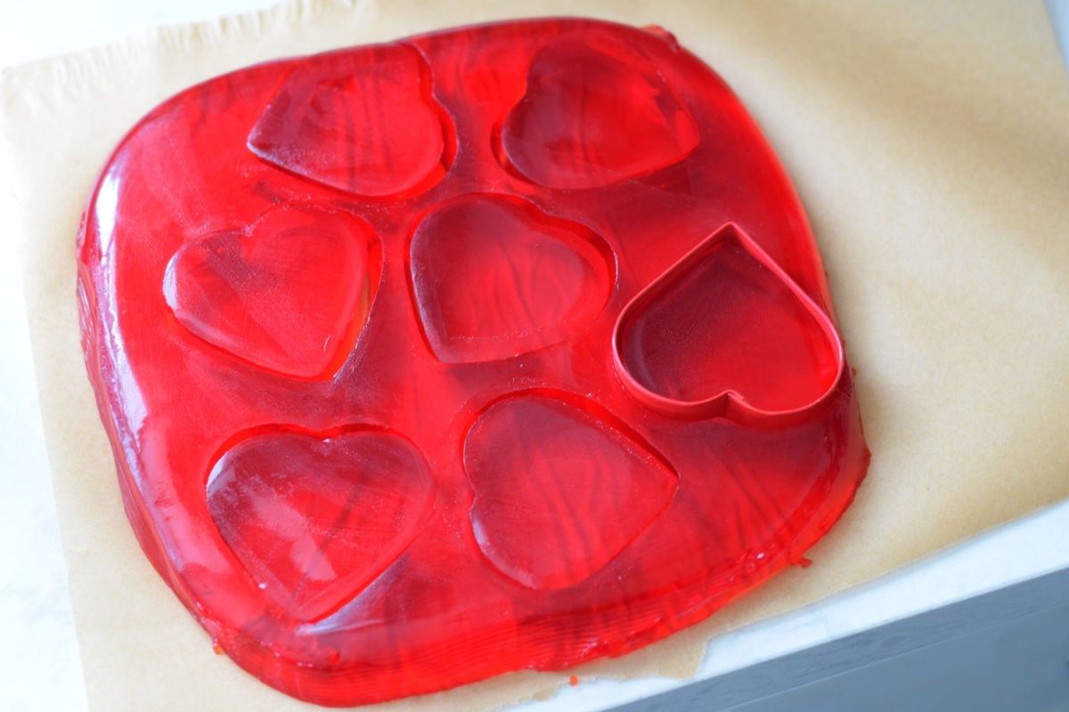 using a cookie cutter to make red Jell-O hearts