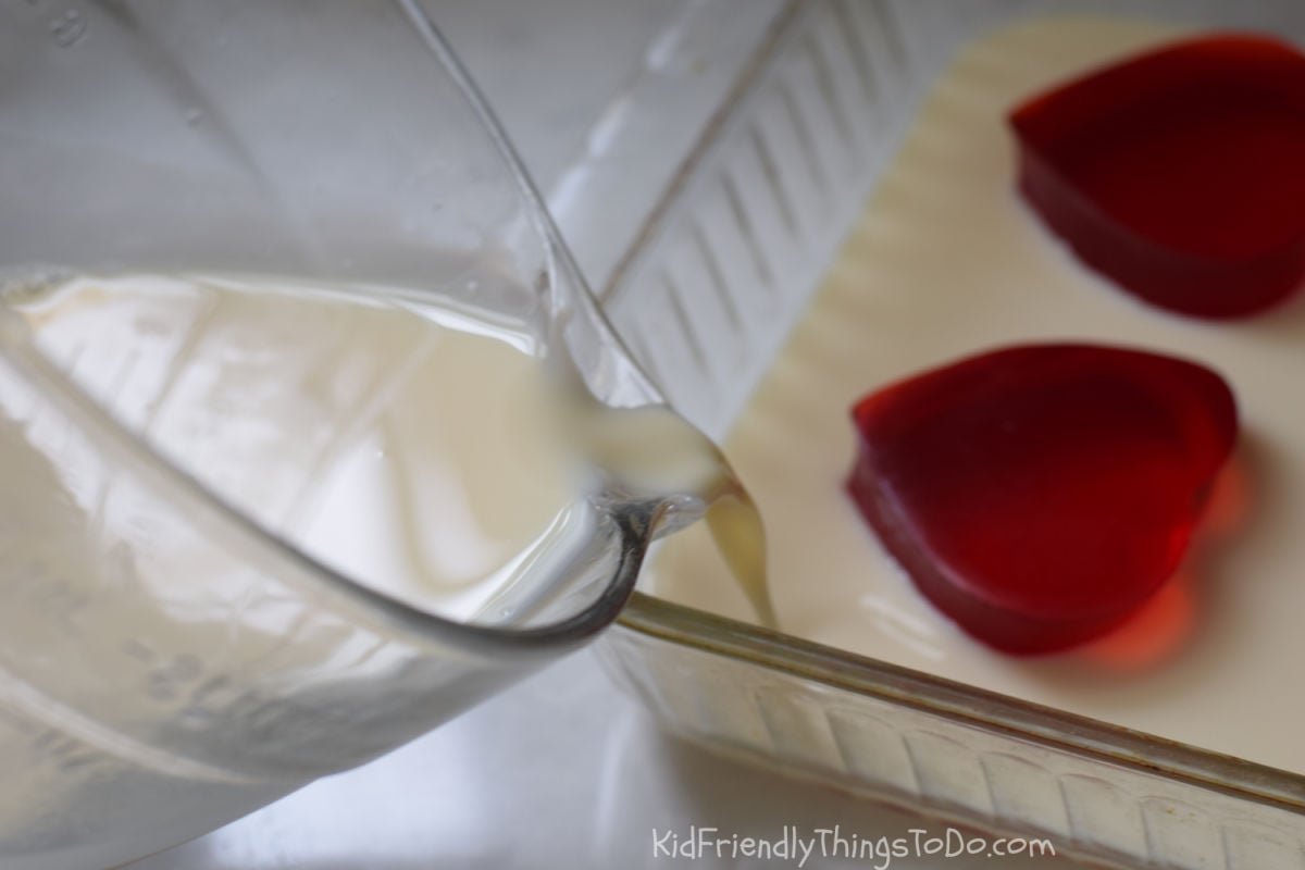 pouring white Jello around red Jello hearts