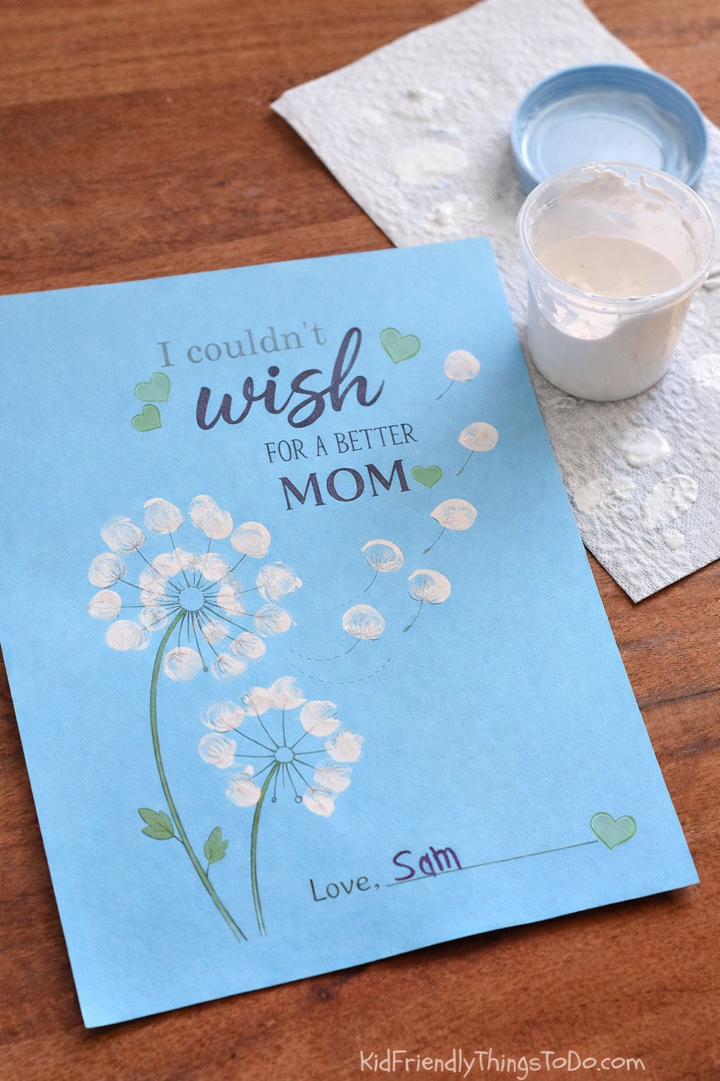 Mother’s Day fingerprint dandelion craft on blue paper with white thumbprint wishes