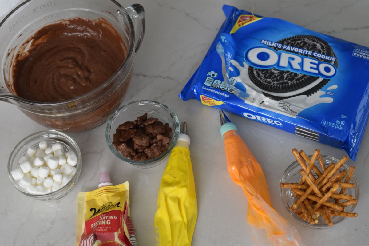 ingredients for campfire dirt cups including pudding, Oreos, frosting, pretzels and marshmallows