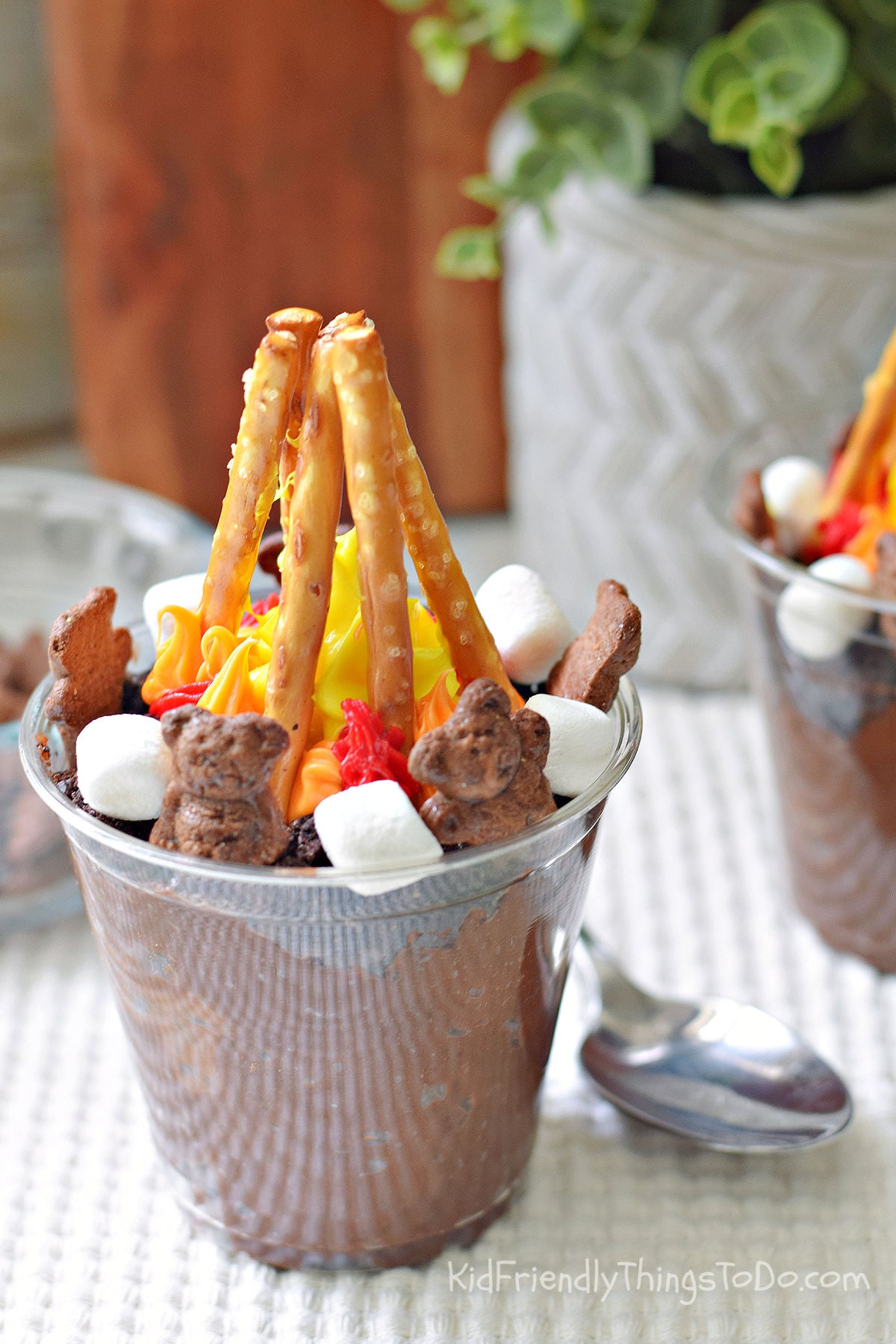 campfire dirt cups made with chocolate pudding, Oreo crumbs, pretzel campfire, marshmallows and Teddy Grahams
