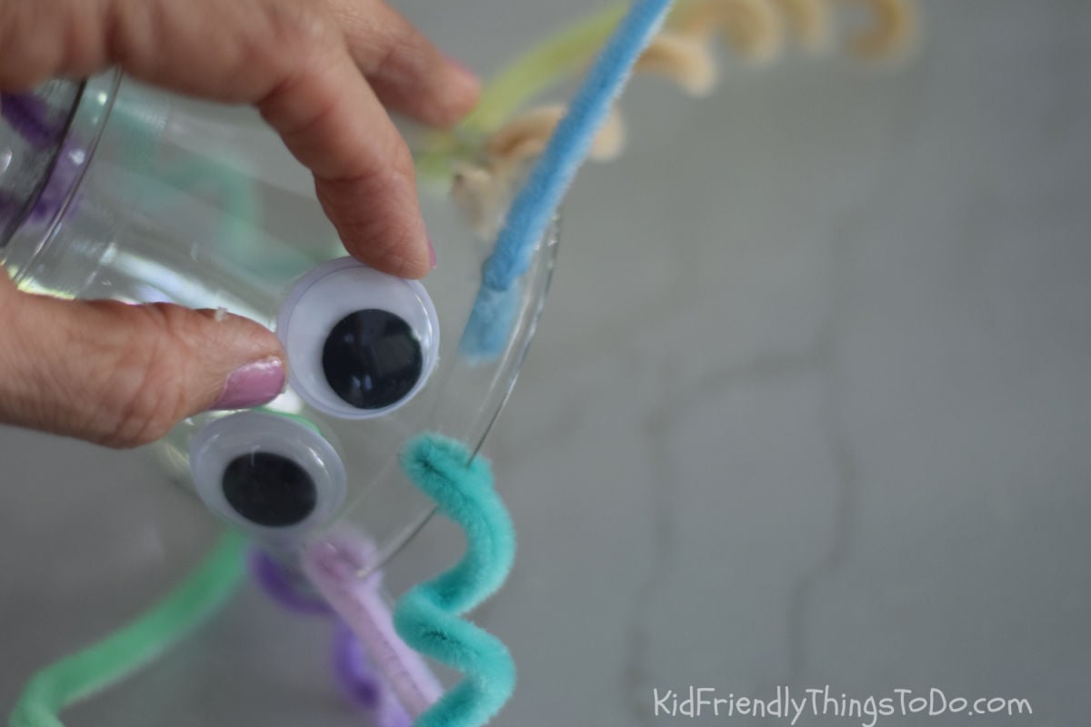 gluing eye onto jellyfish cup craft 