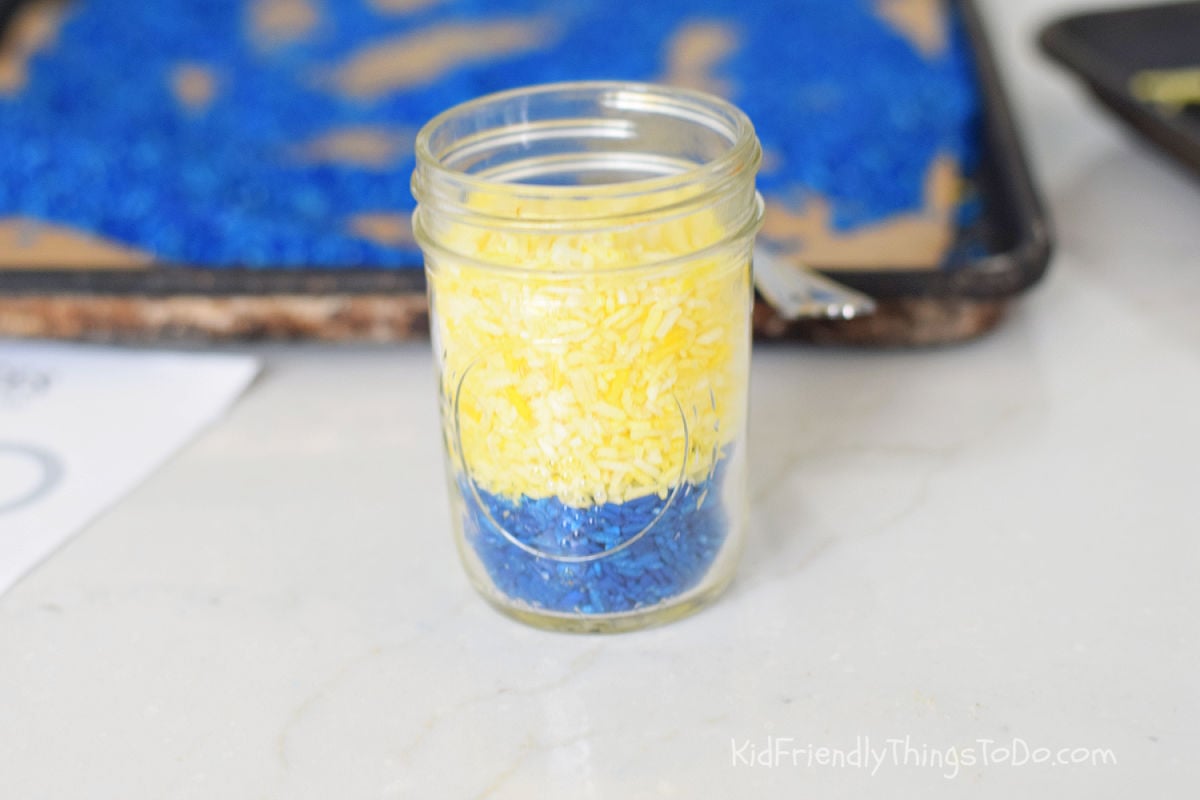 blue and yellow rice in a mason jar for minion jar craft 