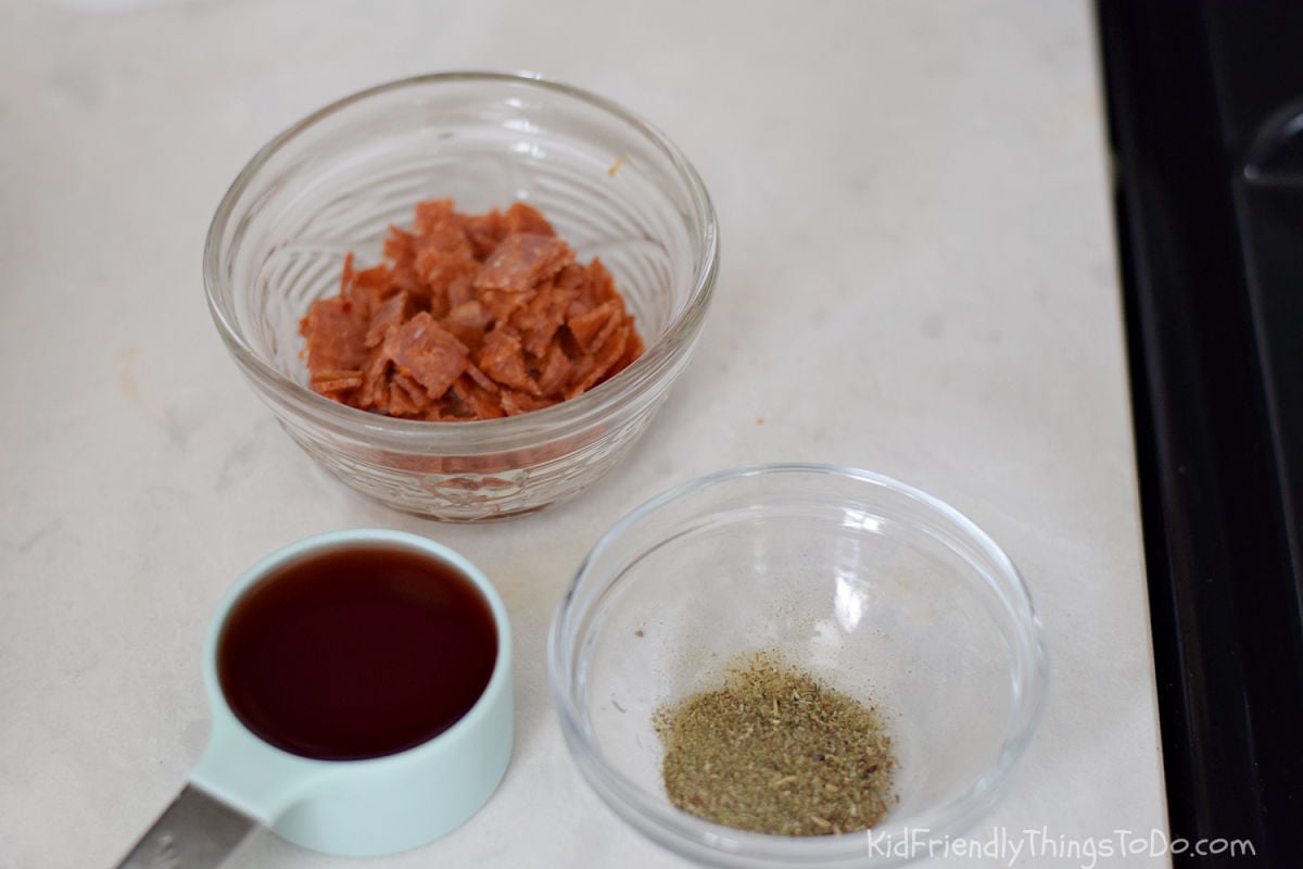 adding pepperoni red wine and spices to meat sauce 