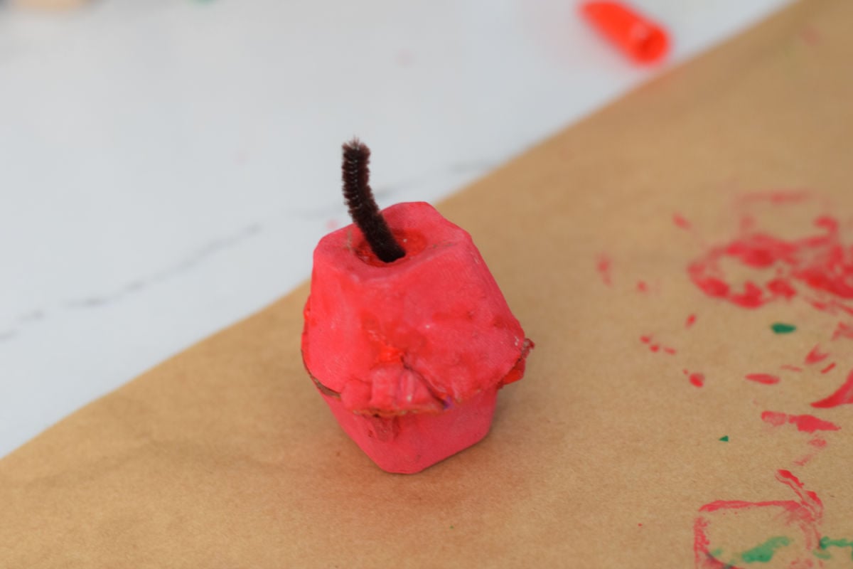 placing a brown stem in an apple egg carton craft 