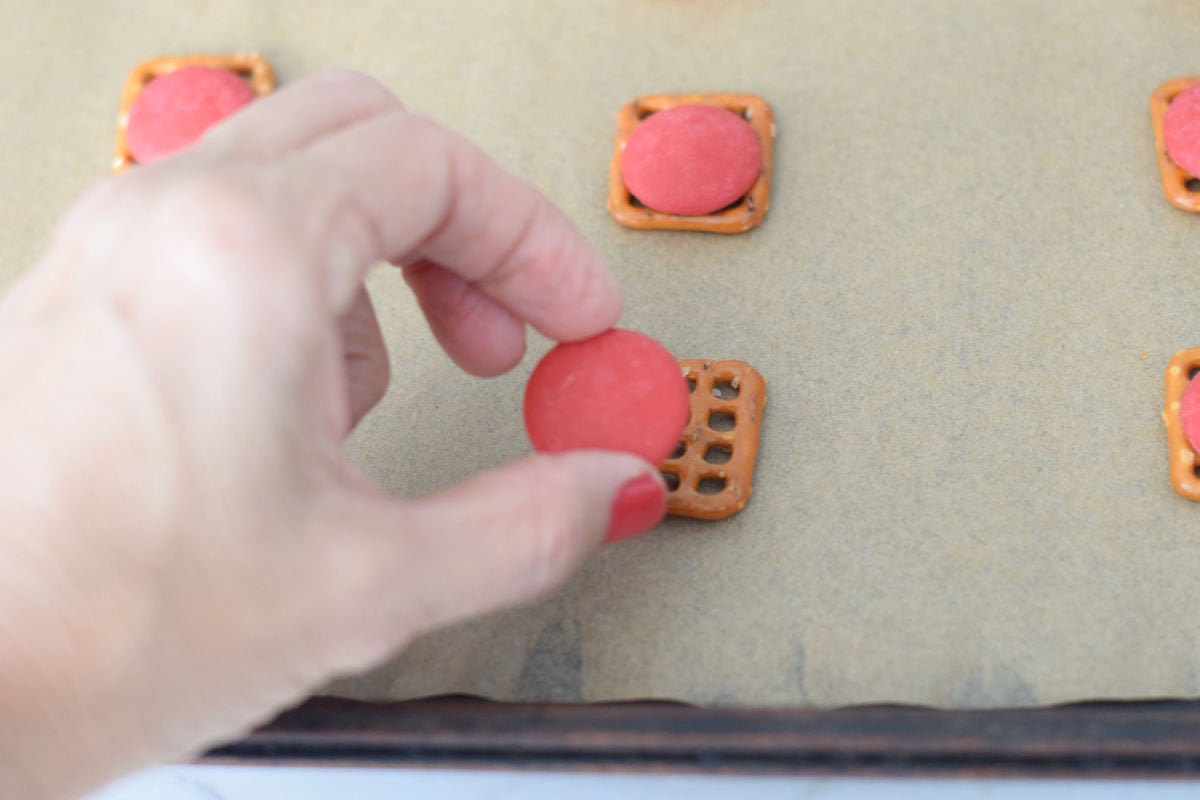 adding red chocolate melts to butter crisp pretzels 
