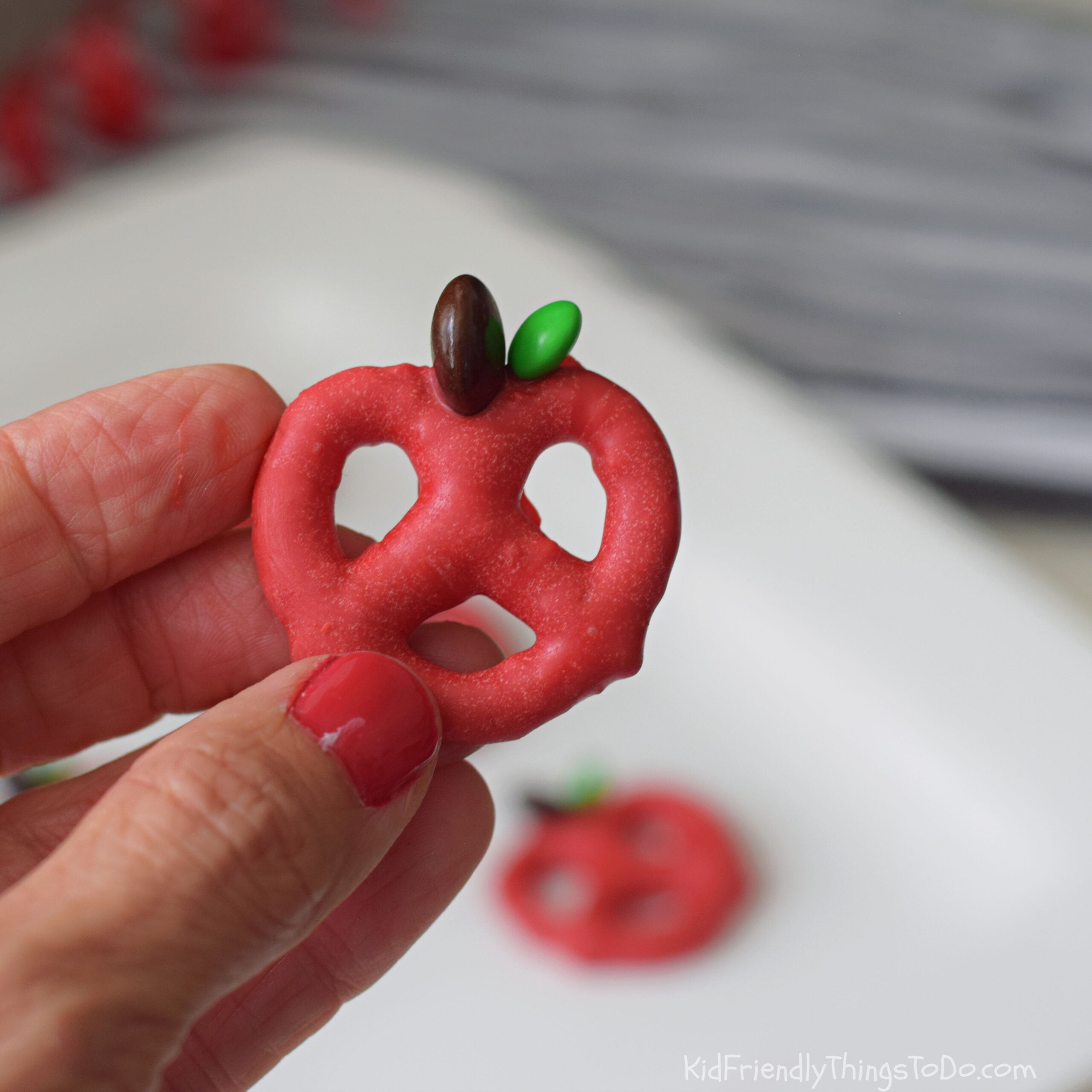 holding apple chocolate dipped pretzels 