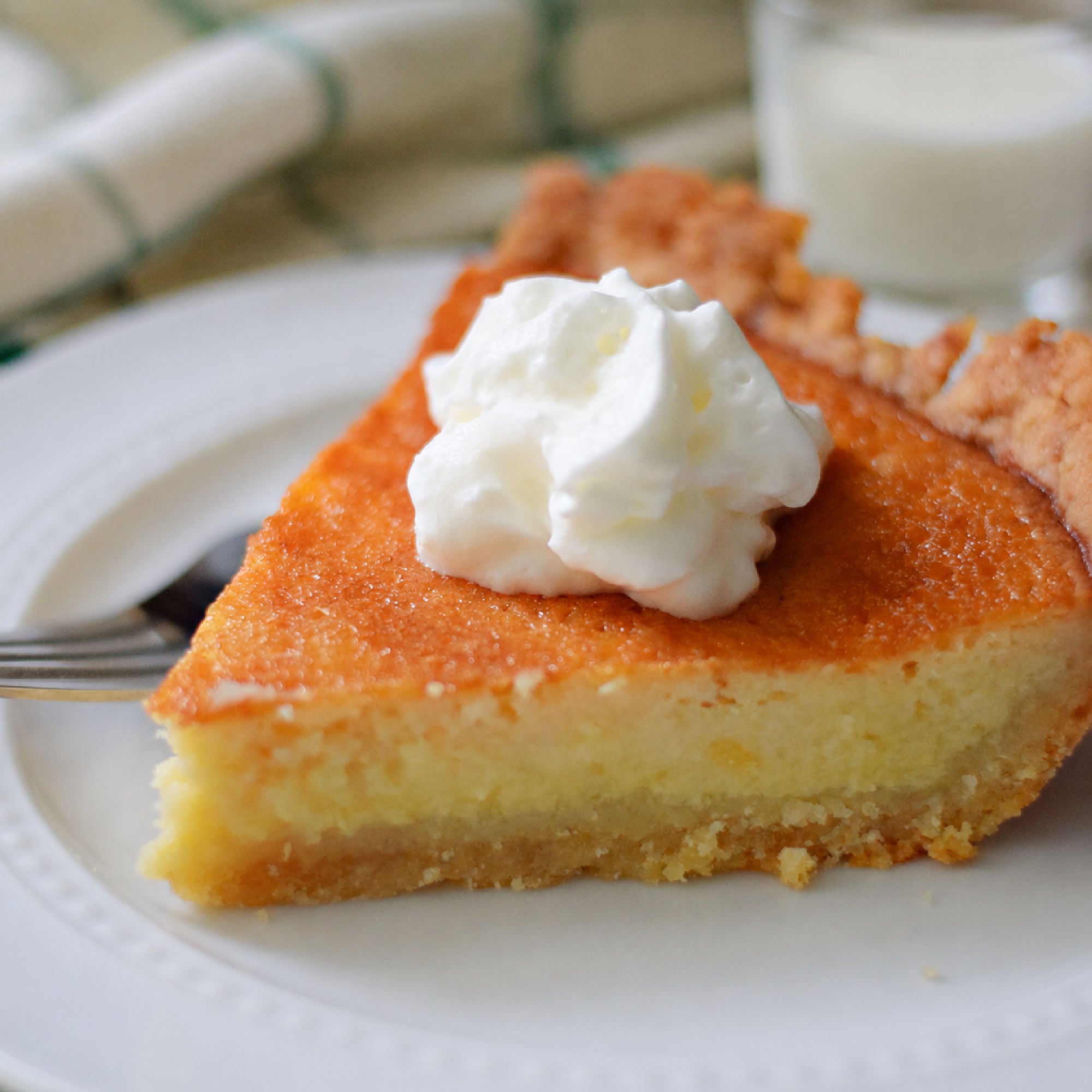 buttermilk pie slice on a plate with whipped cream