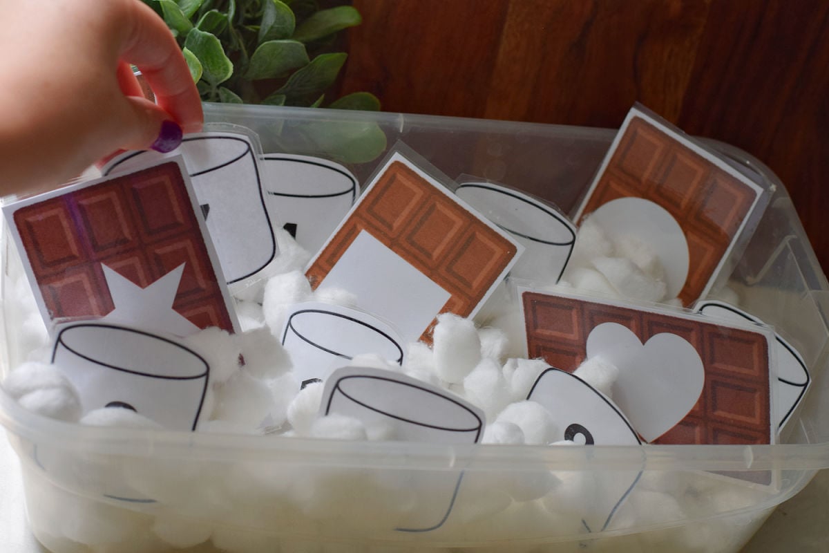 placing printable shapes and numbers in S'mores sensory bin