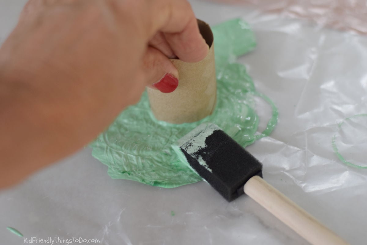 dipping toilet paper tube into paint for cauldron printable craft