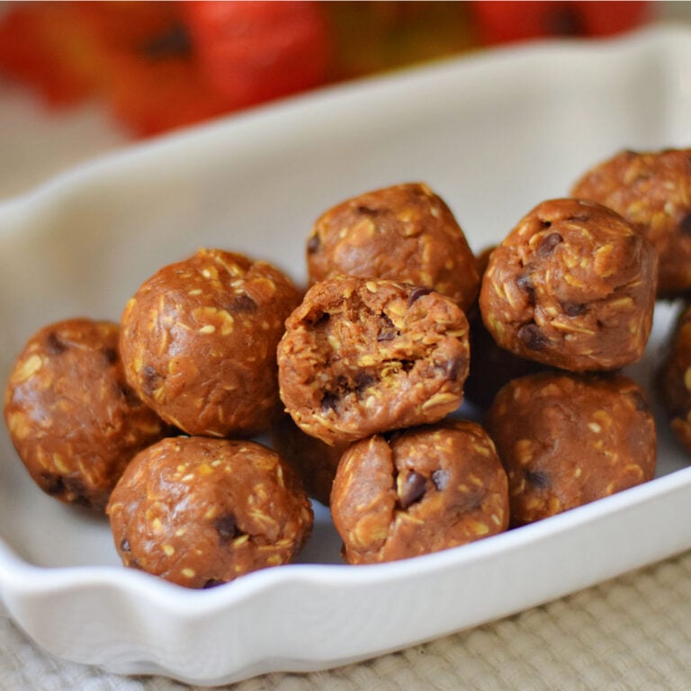 Pumpkin protein balls with one broken open to show the oat and chocolate chip texture