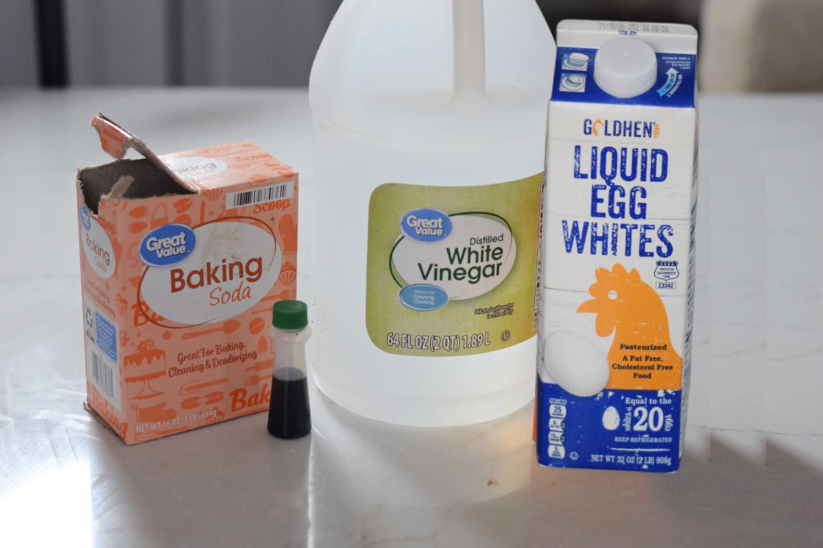 Liquid egg whites, green food coloring, white vinegar, and baking soda for a Frankenstein foam science experiment.