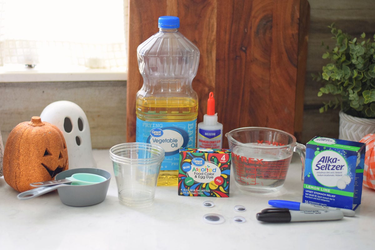 Vegetable oil, water, food coloring, Alka-Seltzer, clear cups, markers, googly eyes, craft glue, and measuring cups.