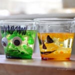 Frankenstein and jack-o’-lantern lava lamp cups with green and orange drops bubbling through vegetable oil.