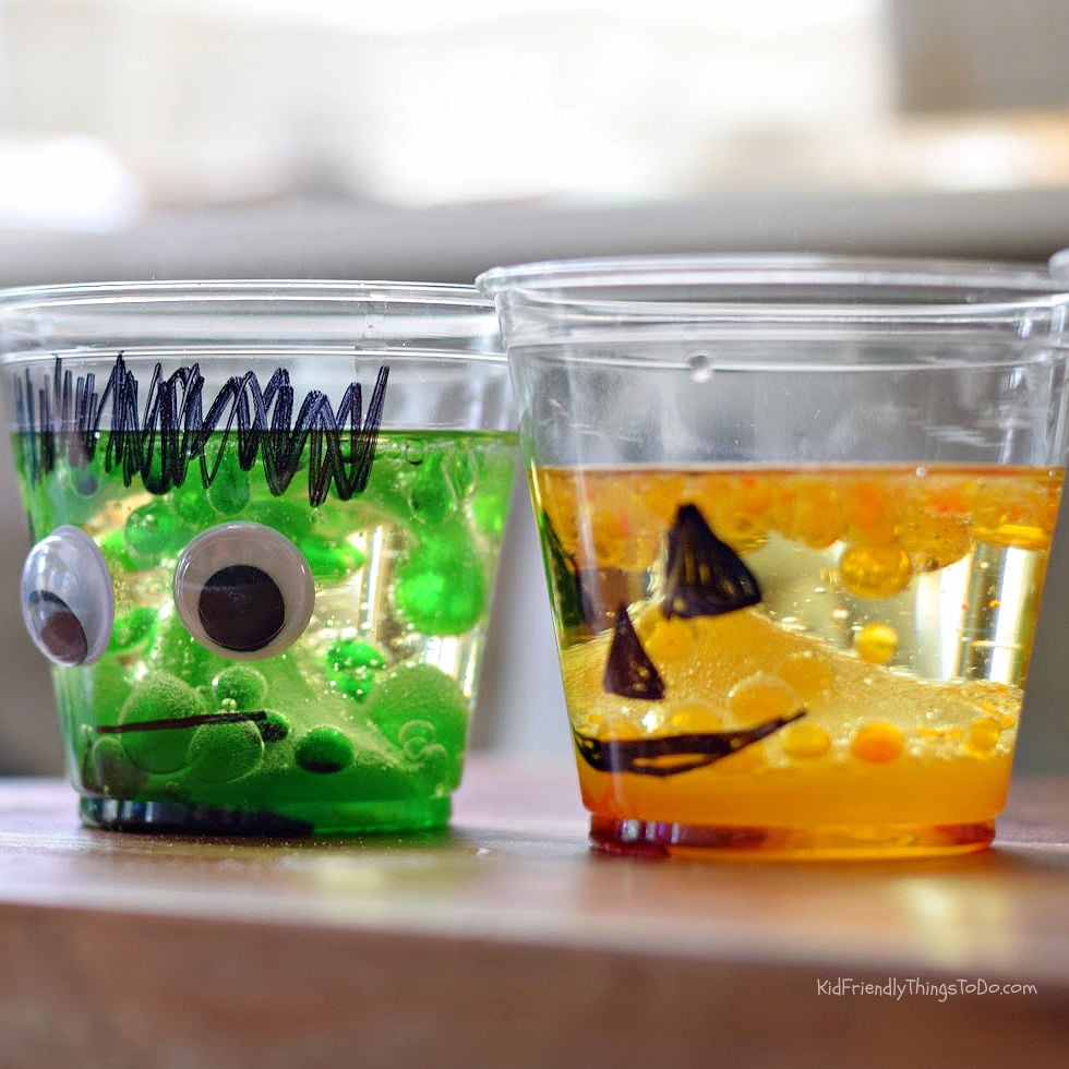 Frankenstein and jack-o’-lantern lava lamp cups with green and orange drops bubbling through vegetable oil.