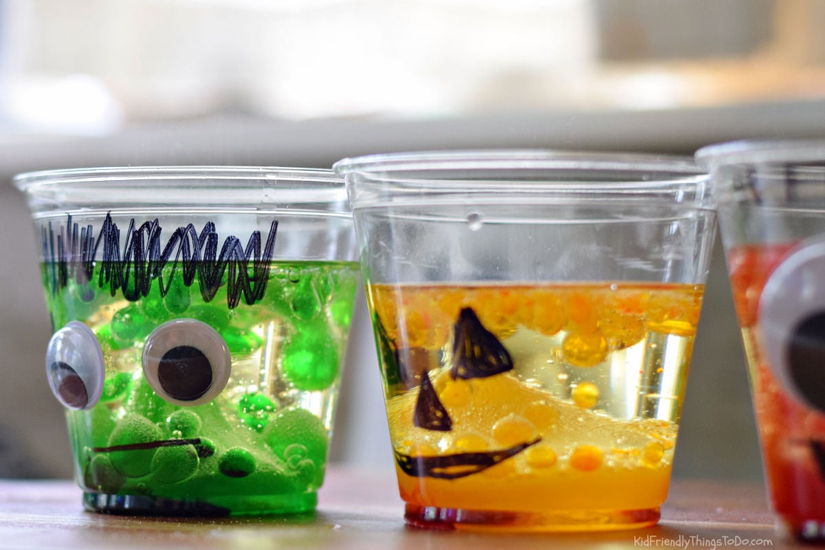Frankenstein and jack-o’-lantern lava lamp cups with green and orange drops suspended in vegetable oil.