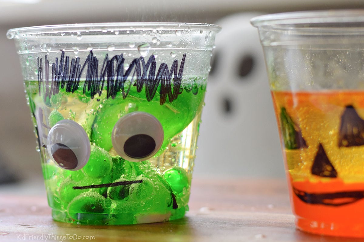 Green colored-water blobs and bubbles inside a clear Frankenstein lava lamp cup.