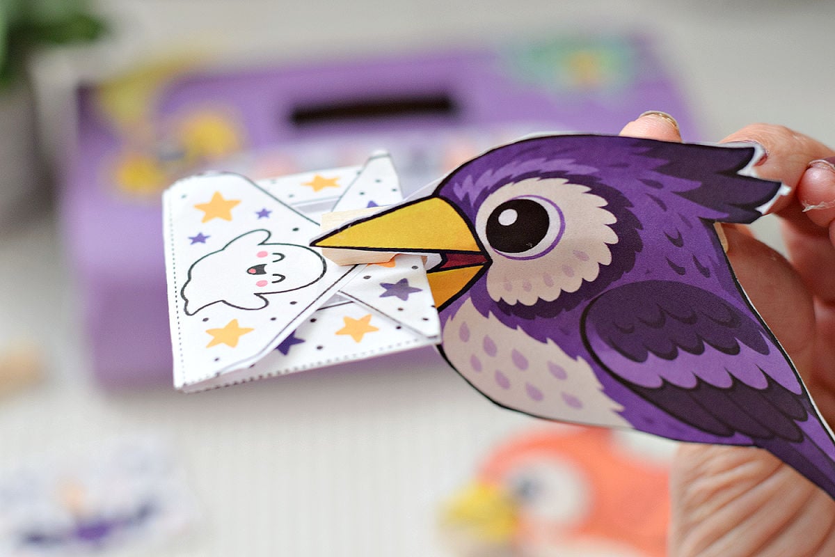 Purple printable owl attached to a clothespin holding a tiny Halloween envelope.