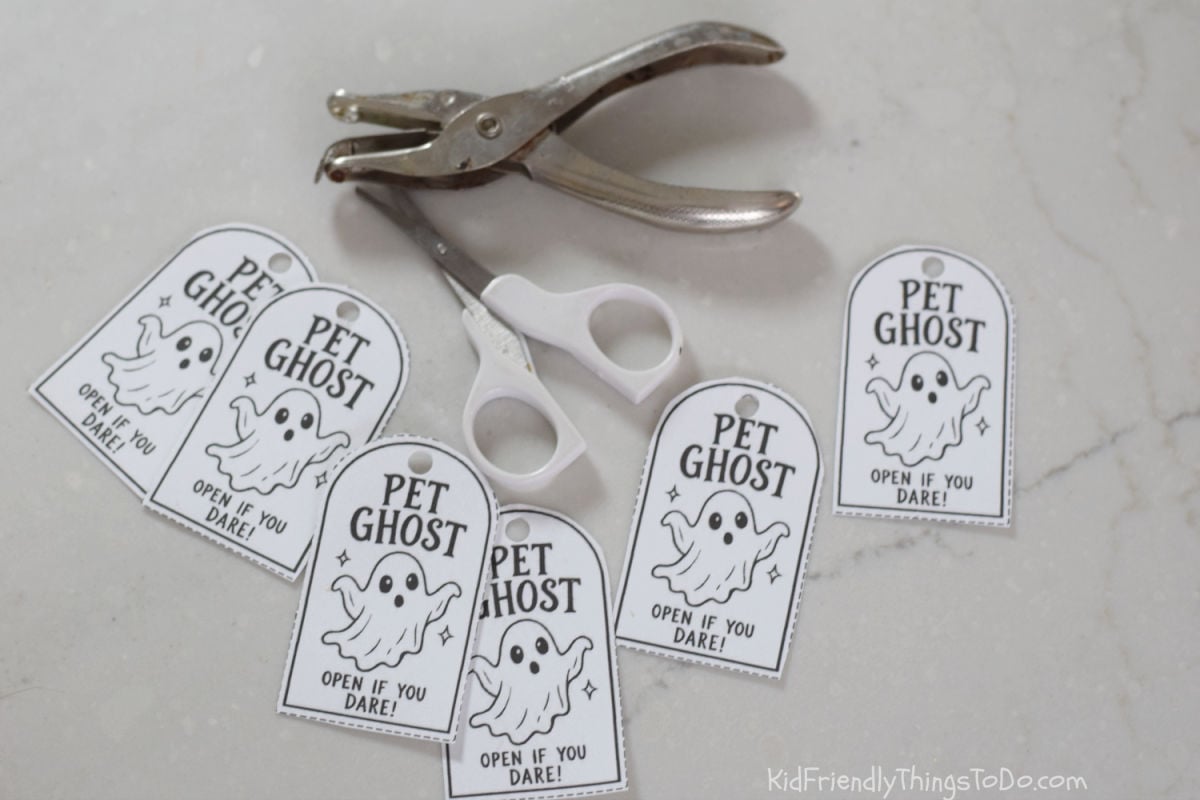 Printable sheet of nine arched Pet Ghost tags featuring a ghost illustration, dashed cutting outlines, and the words “Open if you dare!”