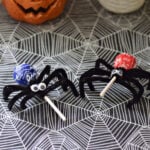 Tootsie Pop spider with a purple wrapper, black pipe cleaner legs, and googly eyes.
