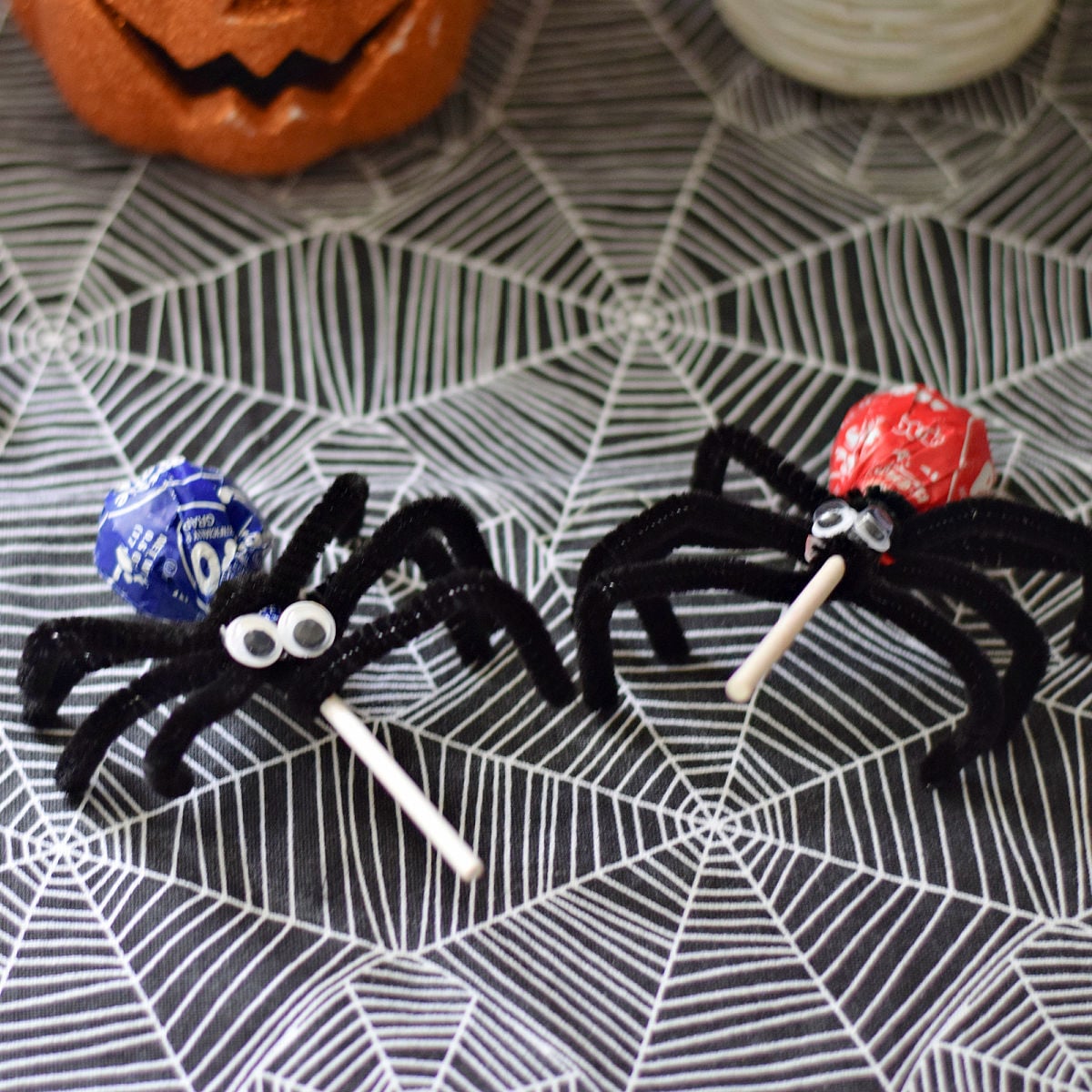 Tootsie Pop spider with a purple wrapper, black pipe cleaner legs, and googly eyes.