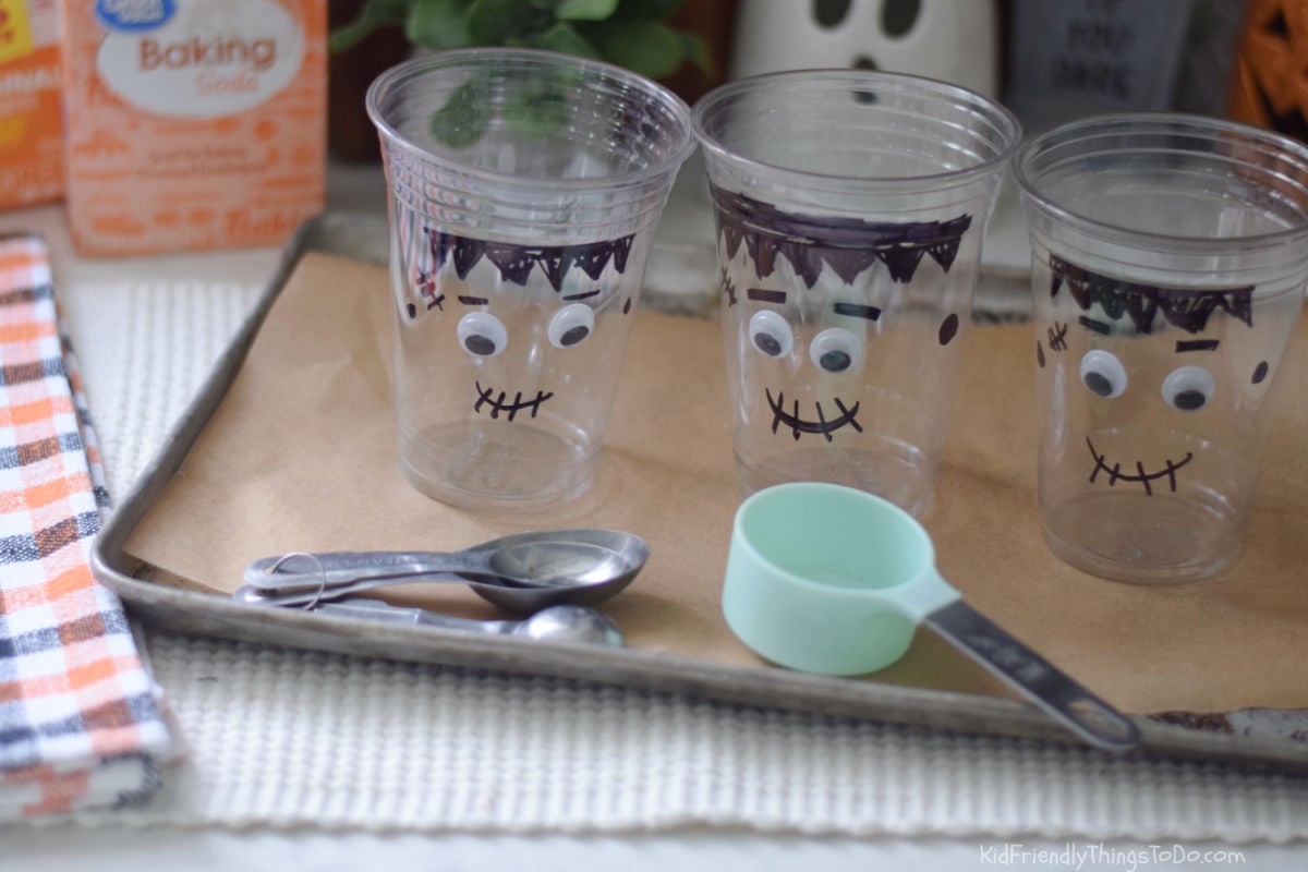 Three empty Frankenstein cups on a baking tray with measuring tools ready for the foam experiment.ki