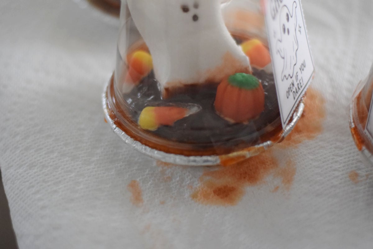 Pet Ghost pudding pie without an Oreo topping, showing orange candy color leaking around the crust and onto a paper towel.