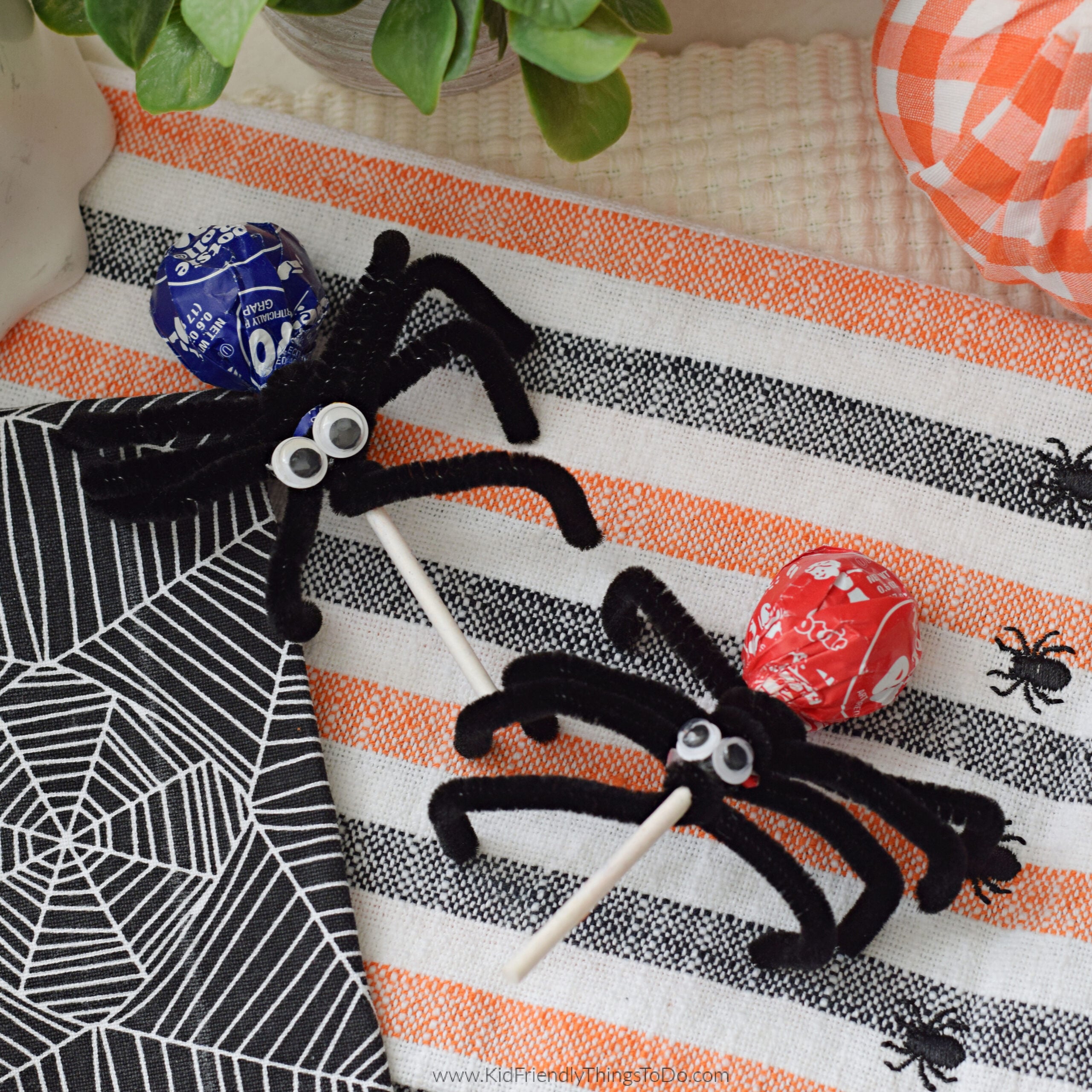 Tootsie Pop spider with a purple wrapper, black pipe cleaner legs, and googly eyes.