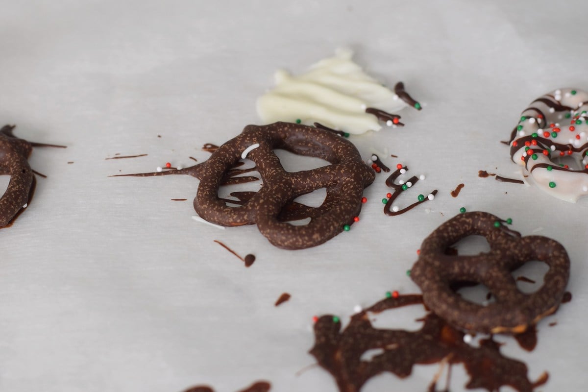 Sugar bloom specks on chocolate covered pretzels after chilling in the fridge.