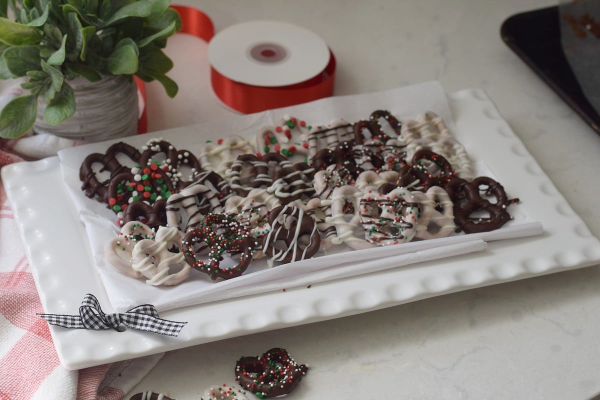 Close view of chocolate covered pretzels with sprinkles and contrasting chocolate drizzle.