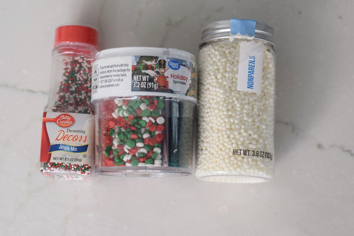 Red, green, and white sprinkles for decorating chocolate covered pretzels.