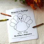 Turkey in disguise printable with a blank turkey outline and crayons on a cream mat.