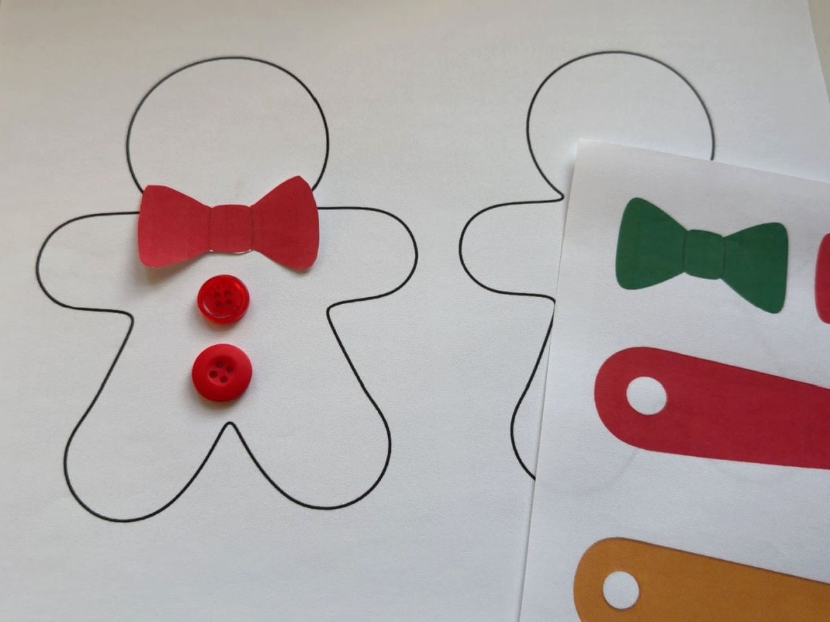 Red bow and buttons placed on a printable gingerbread person to test decoration size