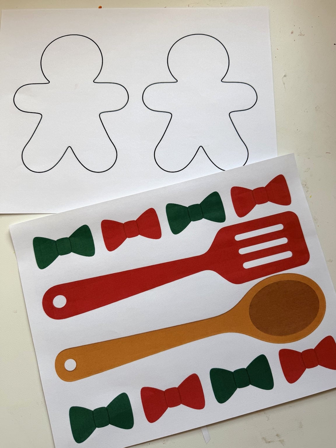 Printed gingerbread man outlines and red and green bow templates for a Christmas classroom bulletin board
