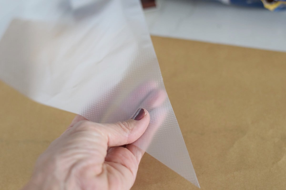 Lining a baking sheet with non-stick paper for chocolate covered pretzels.